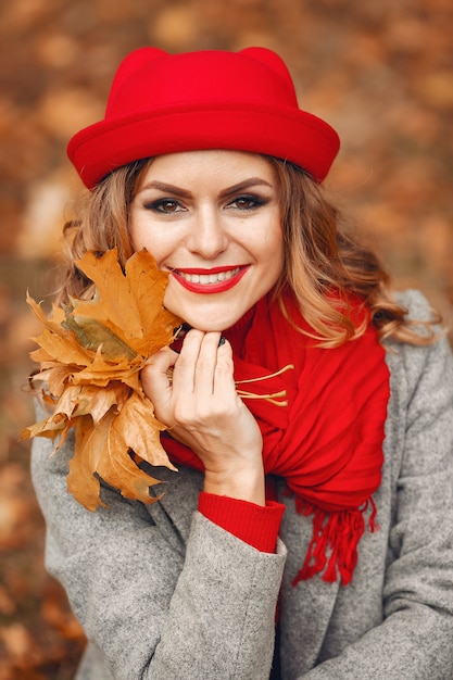 Hermosa mujer sentada en un parque de otoño