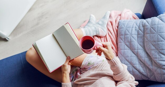 Hermosa mujer en el sofá leyendo