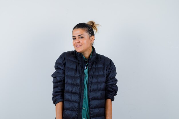 Foto gratuita hermosa mujer sonriendo con gracia mientras posa en camisa verde, chaqueta negra y parece feliz. vista frontal.