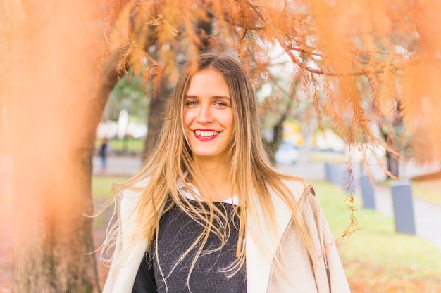 Hermosa mujer sonriente modelo en el otoño de parque