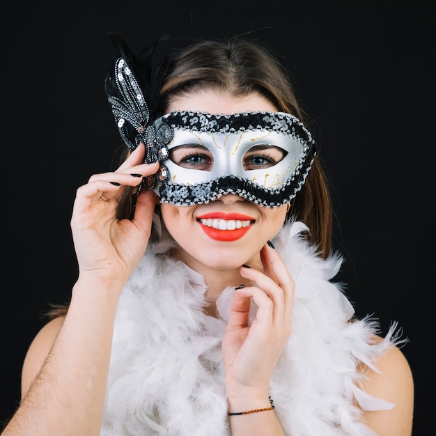 Foto gratuita hermosa mujer sonriente con pluma de boa blanca sobre fondo negro