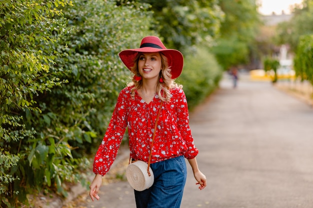 Hermosa mujer sonriente rubia con estilo atractivo en traje de moda de verano de sombrero rojo paja y blusa