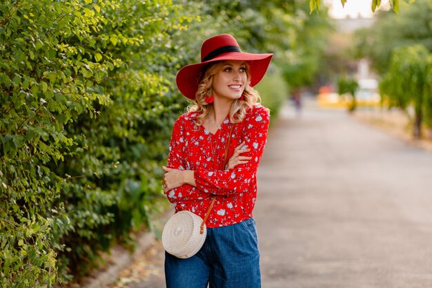 Hermosa mujer sonriente rubia con estilo atractivo en traje de moda de verano de sombrero rojo paja y blusa