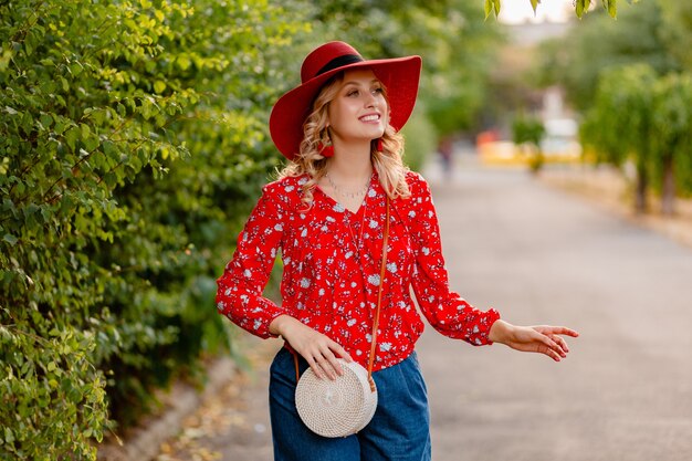 Hermosa mujer sonriente rubia con estilo atractivo en traje de moda de verano de sombrero rojo paja y blusa