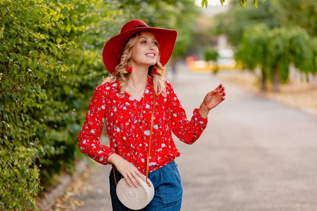 Hermosa mujer sonriente rubia con estilo atractivo en traje de moda de verano de sombrero rojo paja y blusa
