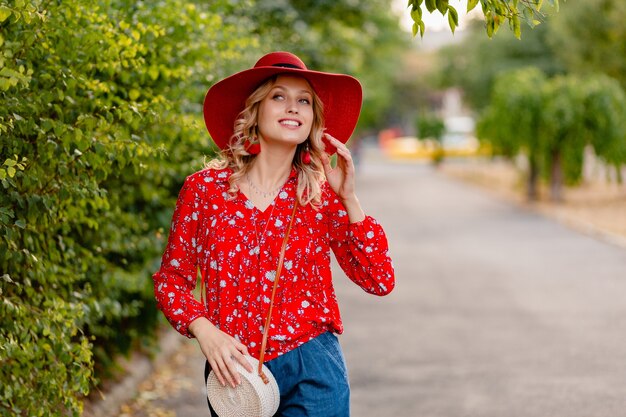 Hermosa mujer sonriente rubia con estilo atractivo en traje de moda de verano de sombrero rojo paja y blusa