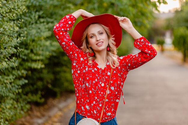 Hermosa mujer sonriente rubia con estilo atractivo en traje de moda de verano de sombrero rojo paja y blusa