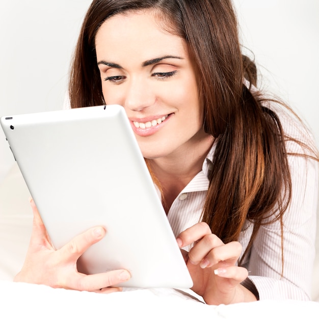 Hermosa mujer sonriente en el sofá con tableta