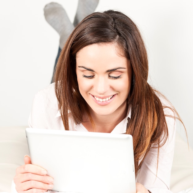 Hermosa mujer sonriente en el sofá con tableta