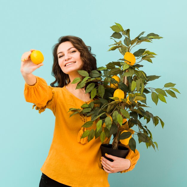 Foto gratuita hermosa mujer sosteniendo un árbol