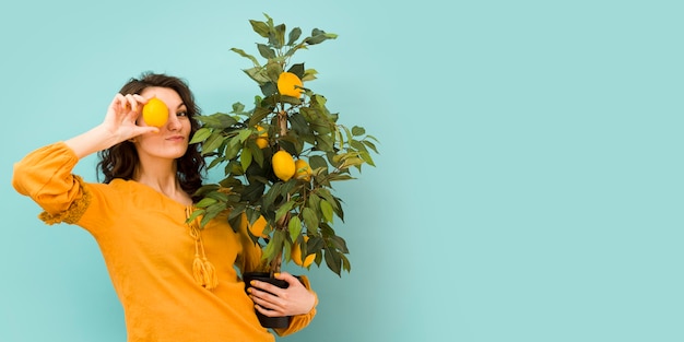 Foto gratuita hermosa mujer sosteniendo un árbol