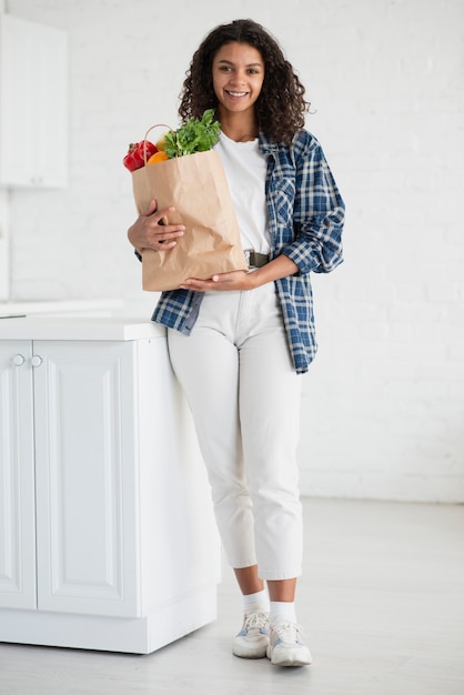 Hermosa mujer sosteniendo una bolsa de verduras