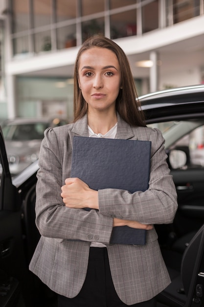 Foto gratuita hermosa mujer sosteniendo una carpeta cerca de su pecho