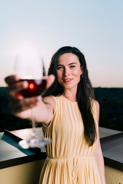 Hermosa mujer sosteniendo una copa de vino en primer plano borrosa