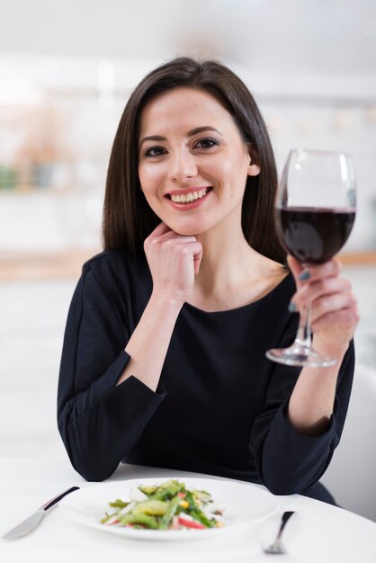 Hermosa mujer sosteniendo una copa de vino tinto