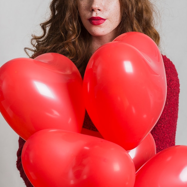 Foto gratuita hermosa mujer sosteniendo globos de corazón