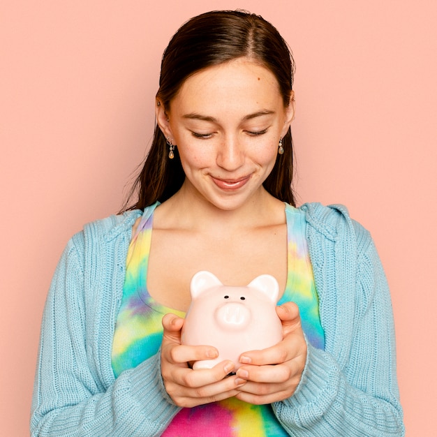 Foto gratuita hermosa mujer sosteniendo hucha para campaña de ahorro financiero