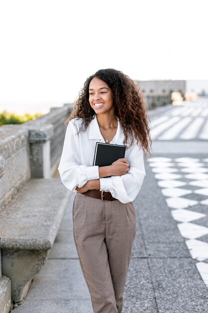 Hermosa mujer sosteniendo un libro al aire libre