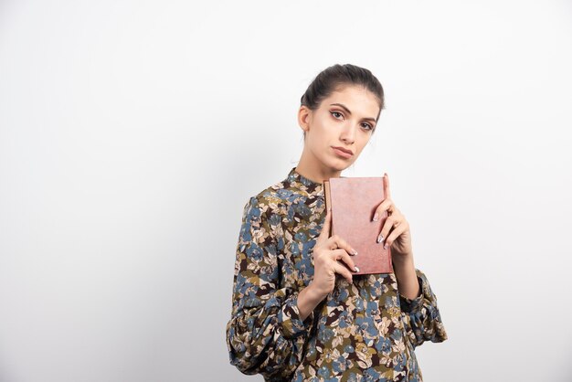 Hermosa mujer sosteniendo el libro con fuerza.