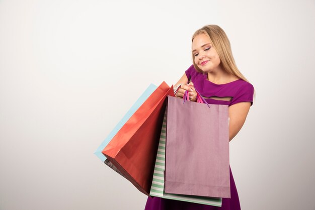 Hermosa mujer sosteniendo un montón de bolsas de la compra.