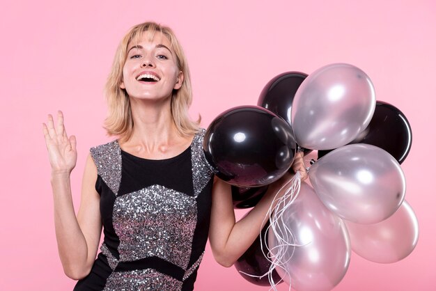 Hermosa mujer sosteniendo un montón de globos