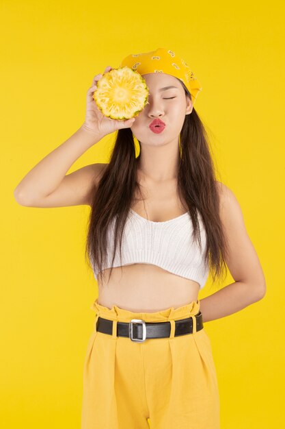 Hermosa mujer sosteniendo una piña