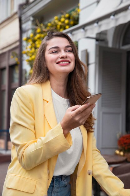 Hermosa mujer sosteniendo smartphone mientras está en bicicleta