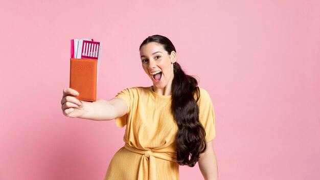 Hermosa mujer sosteniendo su pasaporte y boletos de avión