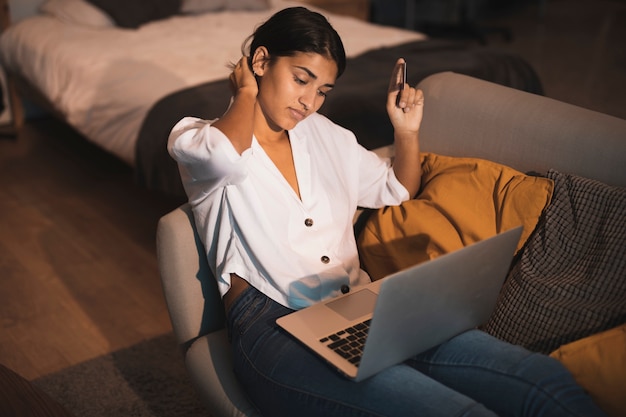 Hermosa mujer sosteniendo una tarjeta y trabajando en la computadora portátil