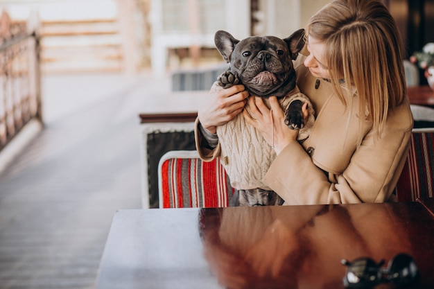 Foto gratuita hermosa mujer con su lindo bulldog francés en traje cálido