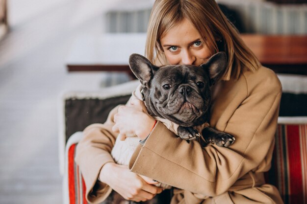 Hermosa mujer con su lindo bulldog francés en traje cálido