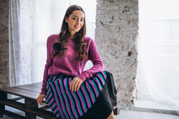 Hermosa mujer en un suéter morado y falda