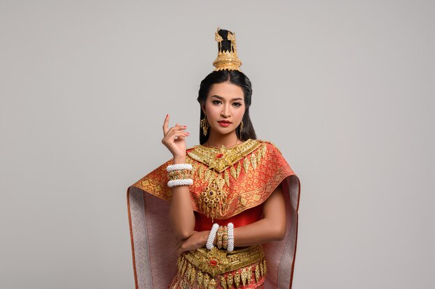 Hermosa mujer tailandesa con vestido tailandés y mirando hacia el lado