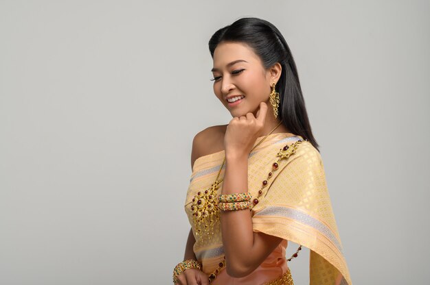 Hermosa mujer tailandesa con un vestido tailandés y una sonrisa feliz.