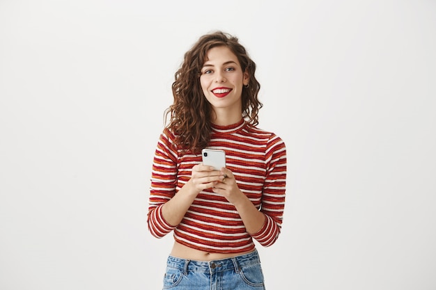 Foto gratuita hermosa mujer con teléfono móvil y sonriendo