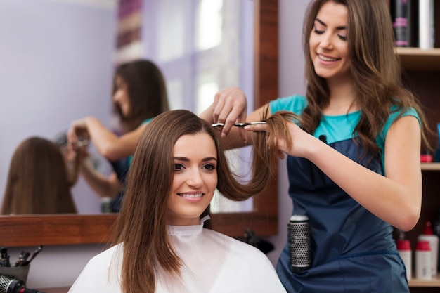 Hermosa mujer tiene corte de pelo en la peluquería