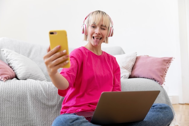 Hermosa mujer tomando un selfie mientras trabaja desde casa