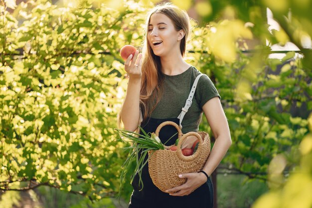 Hermosa mujer trabaja en un jardín cerca de la casa