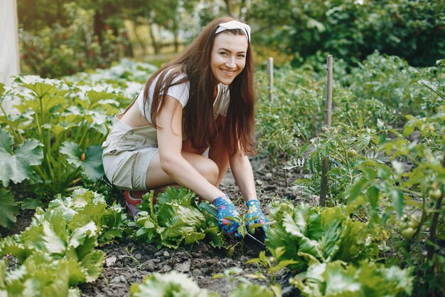 Hermosa mujer trabaja en un jardín