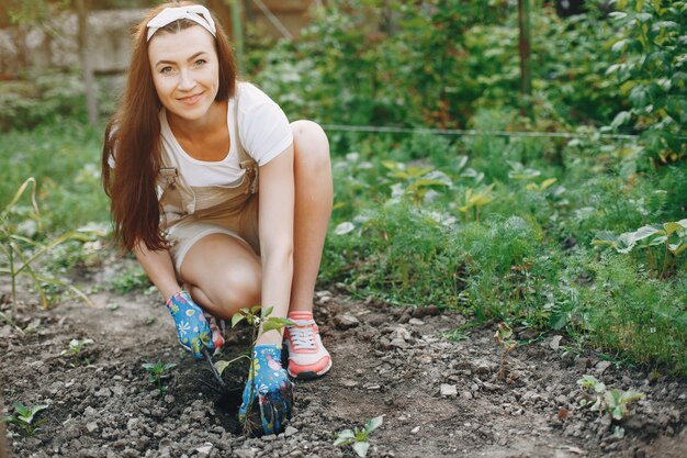 Hermosa mujer trabaja en un jardín