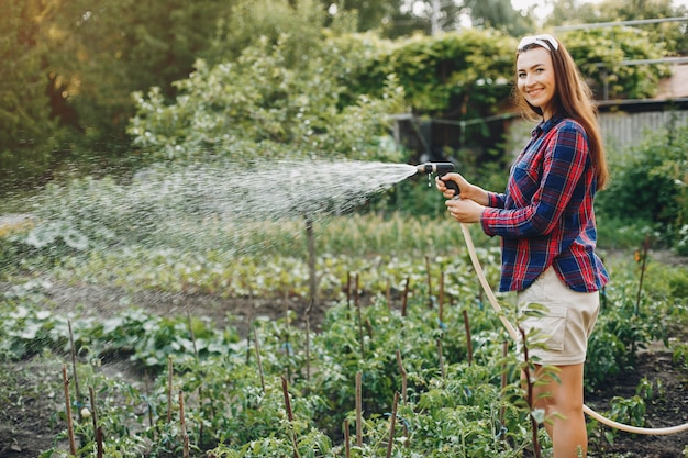 Hermosa mujer trabaja en un jardín