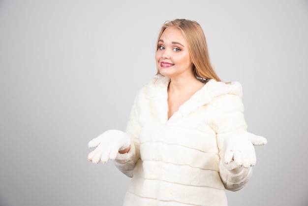 Hermosa mujer en traje de invierno mostrando sus manos.