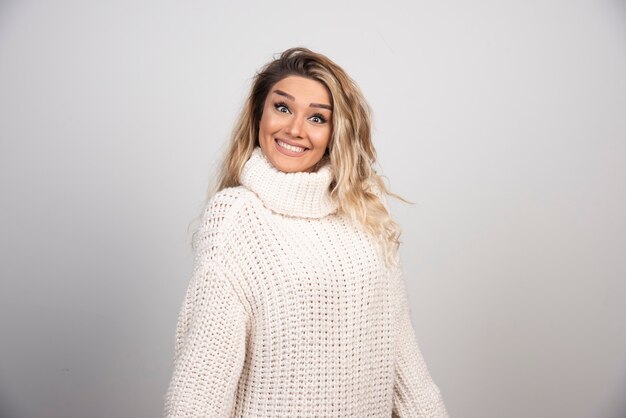 Hermosa mujer en traje de invierno sonriendo felizmente.