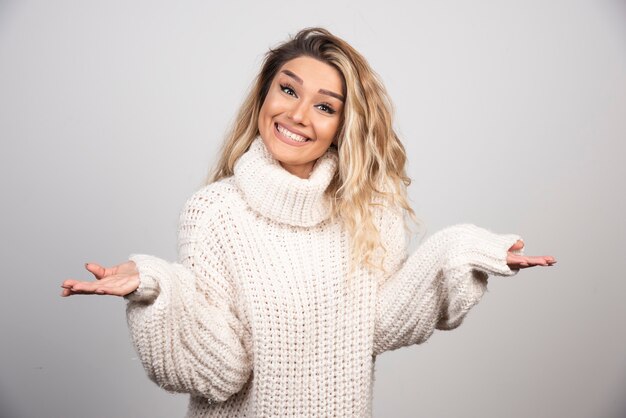 Hermosa mujer en traje de invierno sonriendo felizmente.