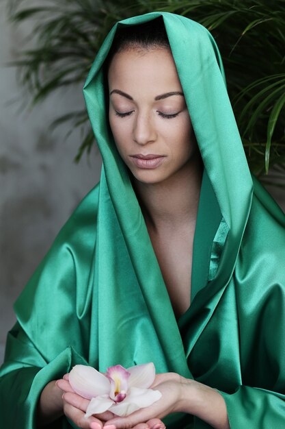 Hermosa mujer con traje tradicional indio y flores en las manos