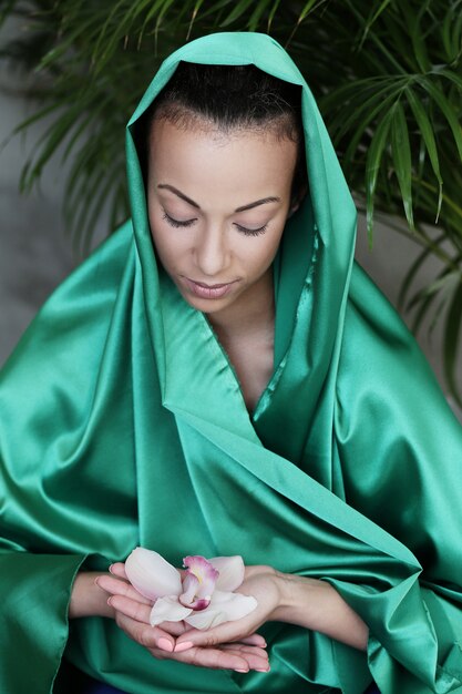 Hermosa mujer con traje tradicional indio y flores en las manos