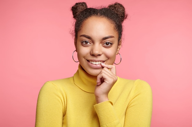 Hermosa mujer vestida con aretes y suéter amarillo