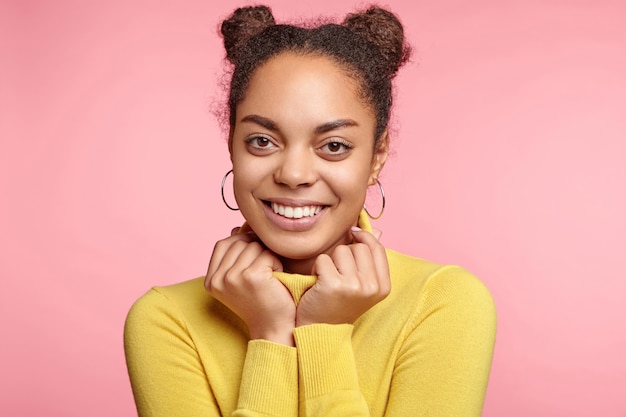 Hermosa mujer vestida con aretes y suéter amarillo