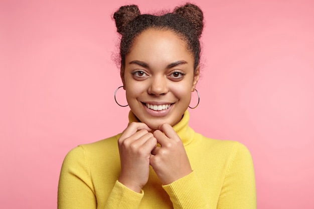 Hermosa mujer vestida con aretes y suéter amarillo