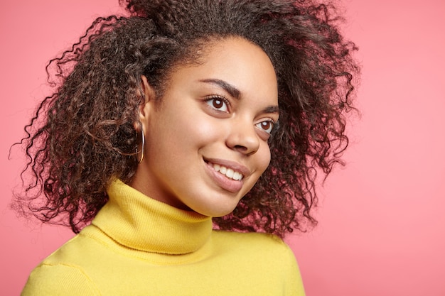 Foto gratuita hermosa mujer vestida con aretes y suéter amarillo